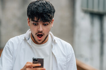 Sticker - young man with mobile phone outdoors with surprised expression