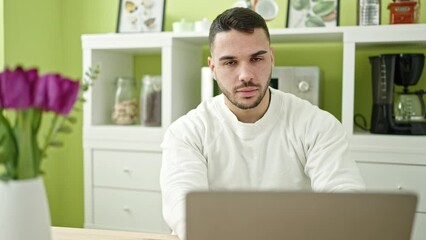 Sticker - Young hispanic man using laptop sitting on table at dinning room