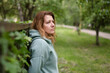 © Мар'ян Філь - Middle-aged woman looks forward and to the side, upset, tired after work, resting in nature in park after a stressful day, woman needs rest and help at work