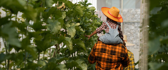 farmer family concept.african man working in greenhouse together with his daughter.black african fat