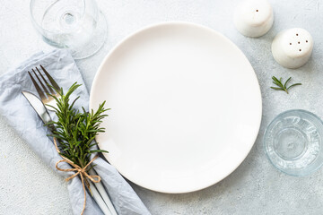 Wall Mural - White plate, shaker, wine glass and cutlery on stone table. Table setting, flat lay image with copy space.