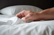 © Clàudia Ayuso - Male hand on soft bed pulling white sheets on bedroom hotel. Pleasure, erotic, ecstasy, orgasm, sex, intimacy and love and concept. Generative AI.