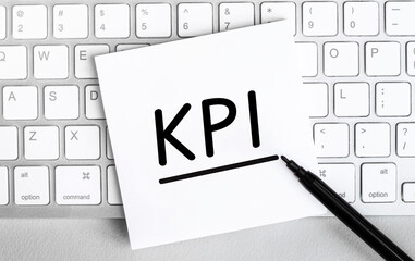 Poster - white paper with text kpi lying on the keyboard