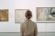 © Neda Asyasi - Young woman looks at paintings in a museum. Woman at art gallery
