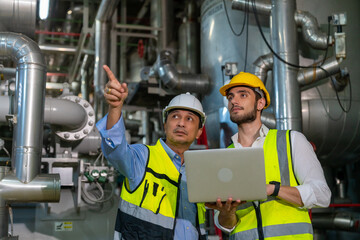 two professional electrical engineer in safety uniform working together at factory site control room