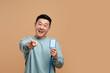 © New Africa - Happy asian man with vip pass badge on beige background. Space for text