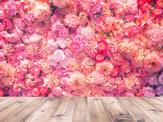 Wall Mural - wood table top over artificial pink flowers bouquet background.