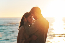 Sunset, Beach And Couple Touching Face For Relaxing, Bonding And Quality Time On Romantic Date. Nature, Love And Man And Woman Embrace For Anniversary Or Honeymoon On Holiday, Weekend And Vacation