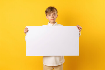 Wall Mural - A12 year old kid wearing cloth holding a blank whiteboard in front of a yellow background, Generative AI