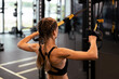 © ty - Women doing pull ups training arms with trx fitness straps in the gym. Upper body training. Back view.
