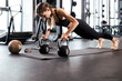 © ty - Slim sporty woman doing push-ups in a gym. Crossfit training.