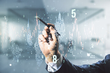 Double exposure of man hand with pen working with abstract creative financial chart hologram on blurred office background, research and strategy concept