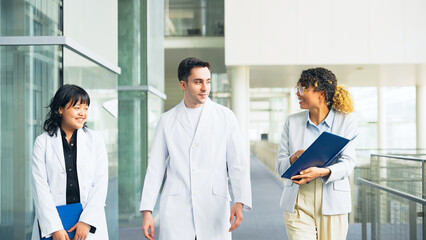 Poster - A multinational group having a conversation in the lobby.
People in white coats and sales staff.