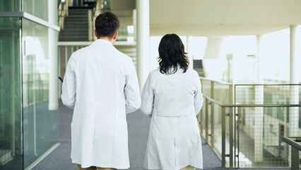 Poster - Multinational group walking in the lobby wearing white coats.