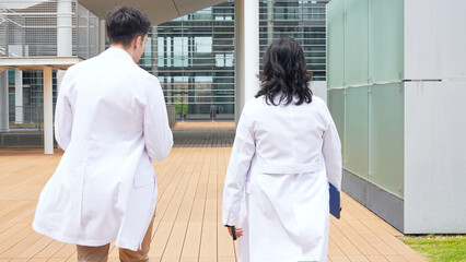 Poster - Multinational group walking in the lobby wearing white coats.
