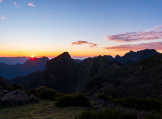 Wall Mural - Sunrise in Madeira mountains peaks in sunlight, scenic view over landscape and Pico Ruivo, Portugal.