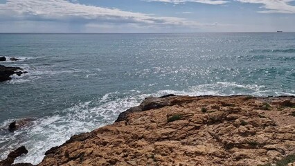 Wall Mural - Province of Castellon. Rocks and turquoise sea with waves. Favorite place for active walks. Oropesa del Mar 