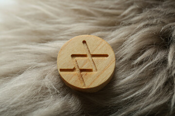 Sticker - Wooden rune Inguz on light faux fur, closeup