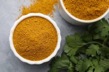 Wall Mural - Aromatic curry powder and parsley on light grey table, flat lay