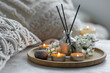 © ArtSys - Aroma diffuser, burning candle, cherry blooming flowers and perfume on wooden bamboo tray. Cozy home decor, hygge and aromatherapy concept. Comfortable atmosphere, spring delicious fresh smell