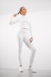 Woman in athleisure standing against white background