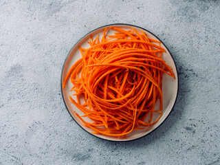 Wall Mural - Raw carrot noodles or spaghetti, top view