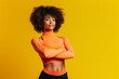 © Joaquin Corbalan - With confidence and power, a young black fitness woman strikes a pose on a vibrant yellow background. Ai generated.