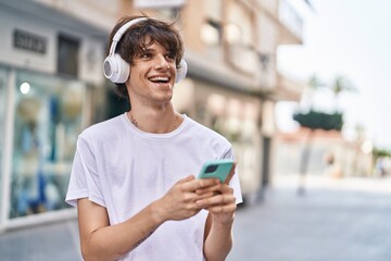 Poster - Young blond man smiling confident listening to music at street