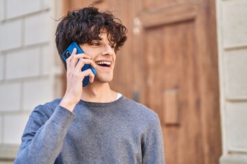 Sticker - Young hispanic man smiling confident talking on the smartphone at street