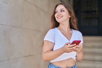 Sticker - Young blonde woman smiling confident using smartphone at street