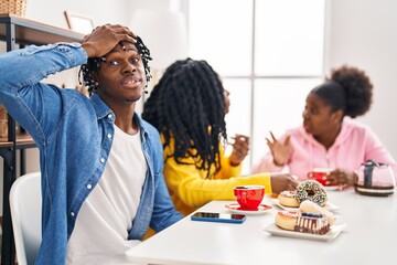 Sticker - Group of three young black people sitting on a table having coffee stressed and frustrated with hand on head, surprised and angry face