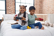 © Krakenimages.com - Adorable boy and girl playing video game sitting on sofa at bedroom