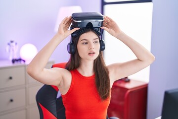 Sticker - Young caucasian woman streamer wearing virtual reality glasses at gaming room