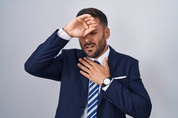 Sticker - Handsome hispanic man wearing suit and tie touching forehead for illness and fever, flu and cold, virus sick