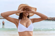 © Krakenimages.com - Young african american woman wearing summer hat doing heart gesture with hands at beach