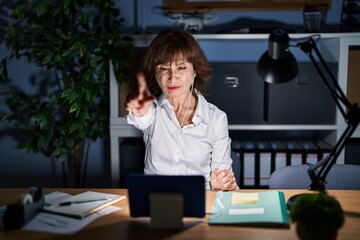 Sticker - Middle age woman working at the office at night pointing with finger up and angry expression, showing no gesture