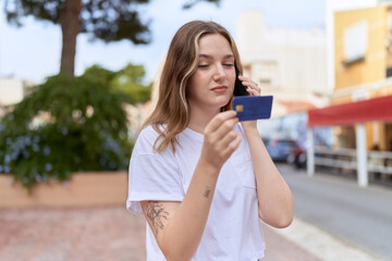 Sticker - Young caucasian woman using smartphone and credit card at street