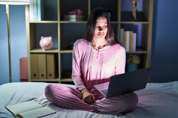 Sticker - Young hispanic woman using computer laptop on the bed depressed and worry for distress, crying angry and afraid. sad expression.