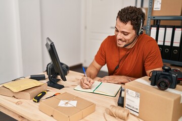 Sticker - Young hispanic man ecommerce call center agent having video call writing on notebook at office