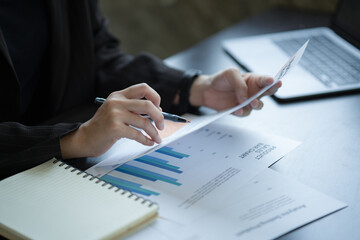 Fototapete - Close-up of Asian Businesswoman working at the home office and analyzing financial report document. Accounting and Finance concept.