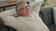 © Krakenimages.com - Middle age grey-haired man relaxed with hands on head sitting on sofa at home