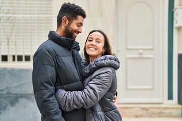 Canvas Print - Man and woman couple smiling confident hugging each other at street