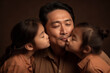 © Loks - Asian mid father and children hugging and kissing on a dark brown background, generative ai