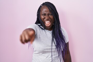 Sticker - Young african woman standing over pink background pointing displeased and frustrated to the camera, angry and furious with you