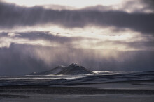 Sunlight Through Clouds In A Snowstorm Over A Remote Landscape, Iceland