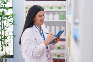 Sticker - Young beautiful hispanic woman pharmacist using touchpad working at pharmacy