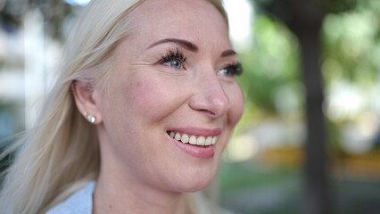 Poster - Young blonde woman smiling confident looking to the side at park