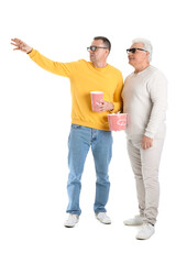 Poster - Mature brothers in 3D glasses with popcorn on white background