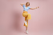 © gstockstudio - Full length of fashionable young woman dancing and smiling against color background