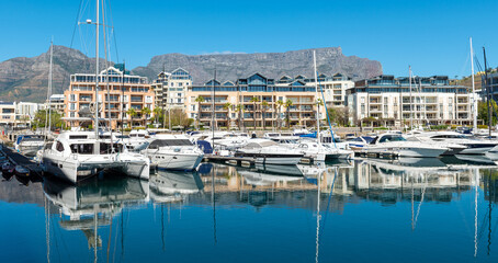 Wall Mural - Yachts panorama in Cape Town harbour marina with Table Mountain reflection, Cape Town, South Africa.